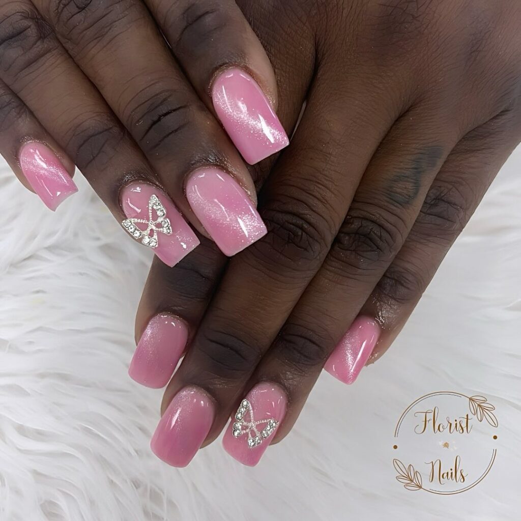 pink nails with white dimensional line and butterfly gems