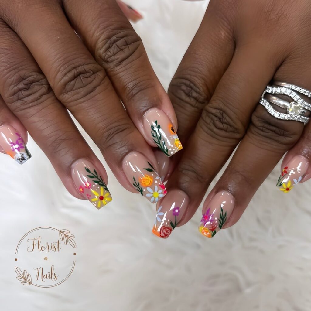 hands with nails that have floral designs in multiple colors