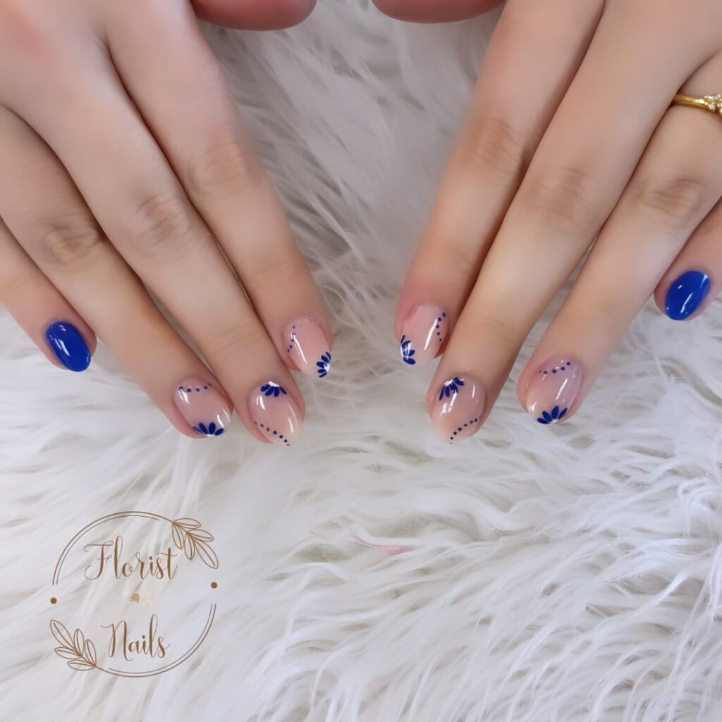 hands with nails polished in blue and flowers design